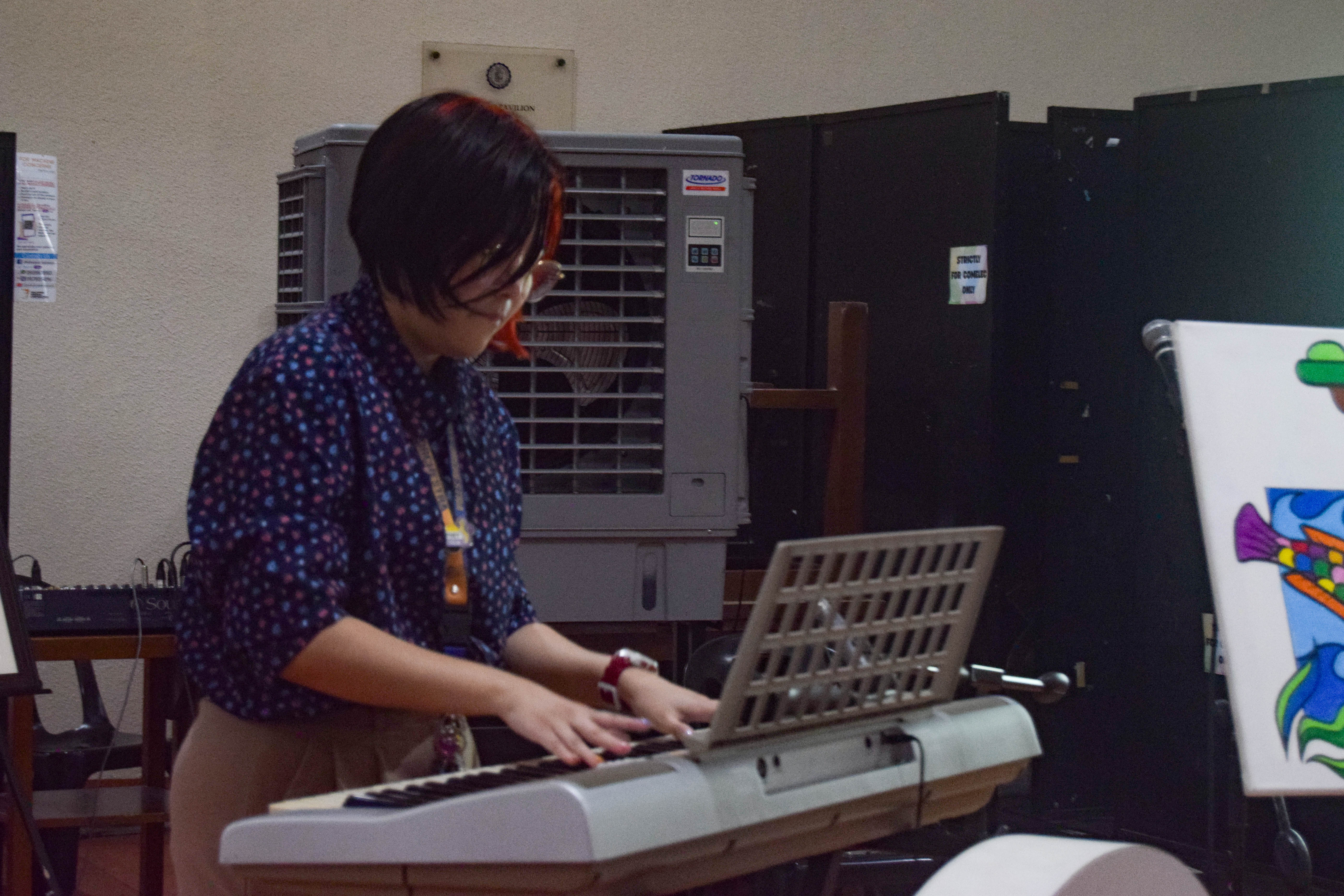 Mx. Gloria, AIS Comms Officer, performed on the piano after unveiling the completed interactive painting