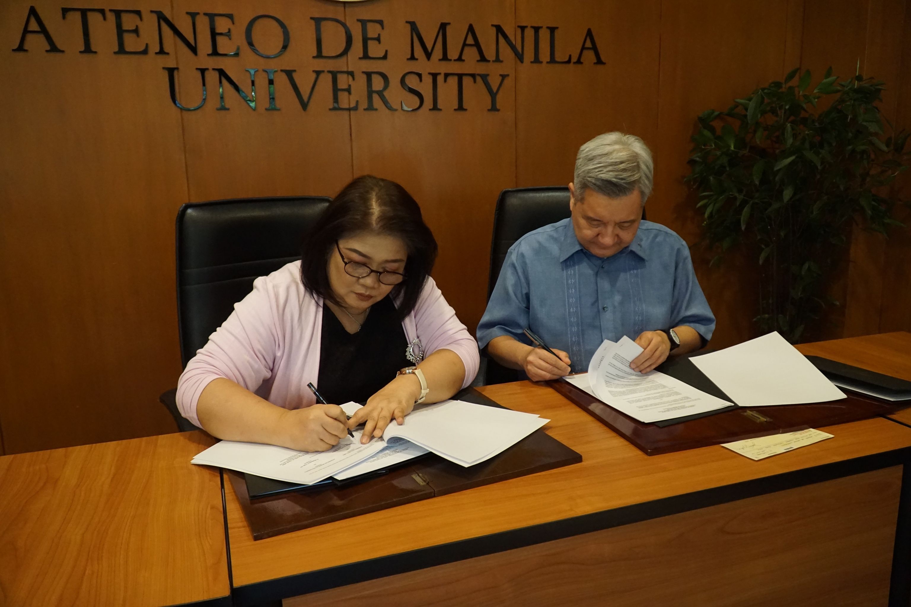 Ms. Julie Javellana-Santos signs the MOA with Fr. Bobby Yap