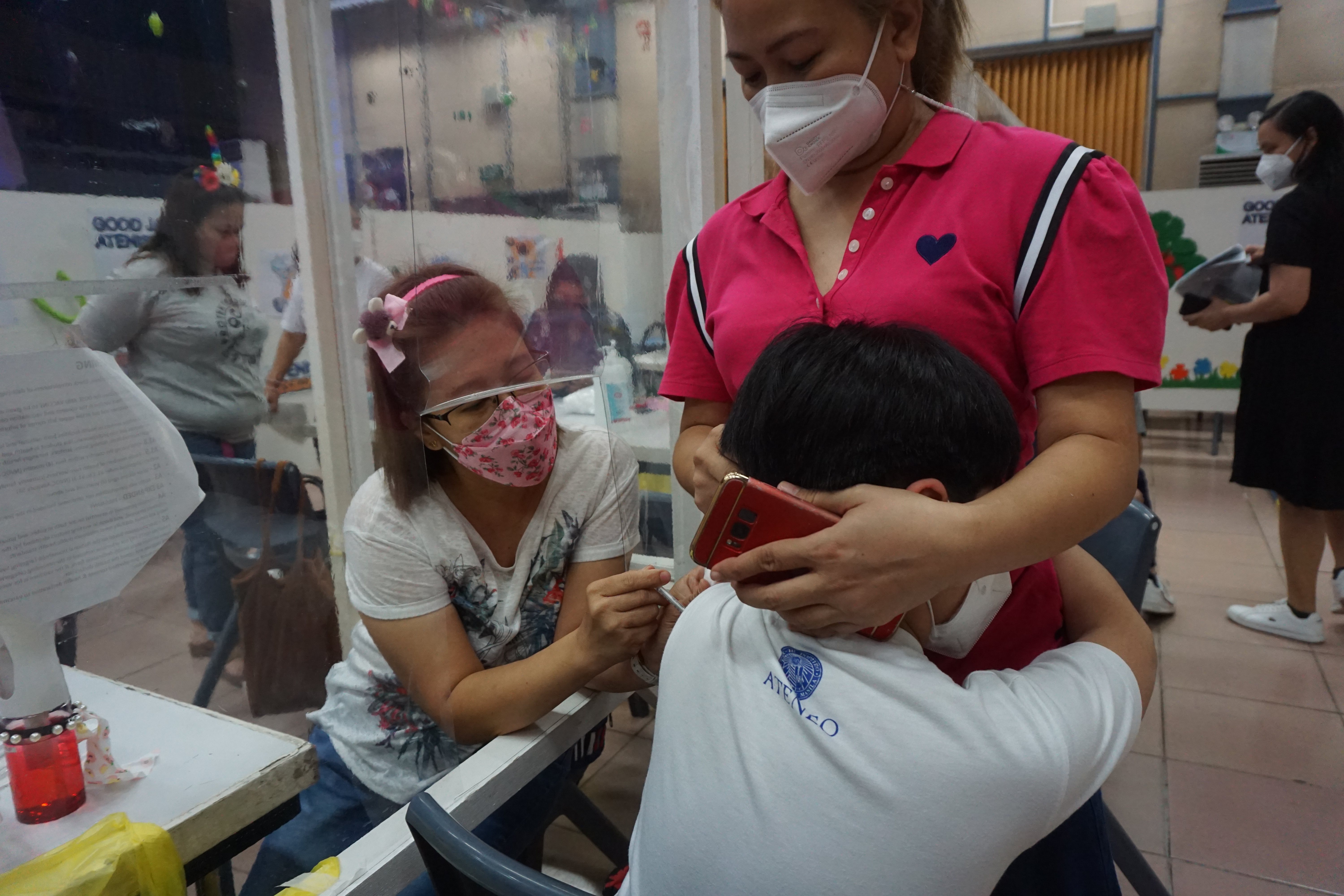 Jap, grade 5, hugs his mom tight as he is inoculated