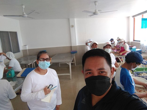 Efren Gumayan (in black) with the processing plant owner and workers