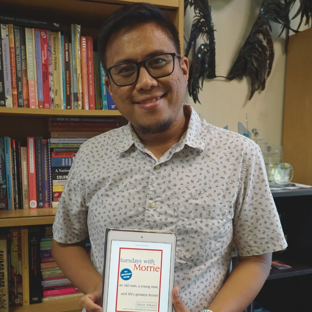 Jethro Tenorio poses with a copy of Tuesdays With Morrie