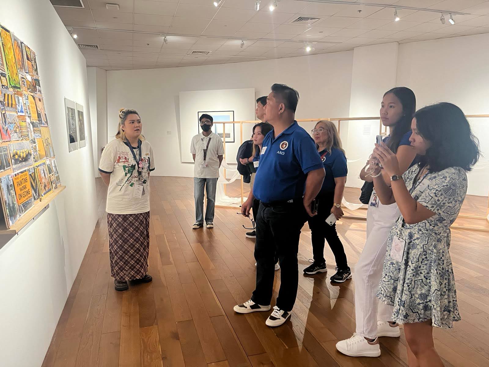 Ateneo de Naga University’s Office of Alumni Relations (ADNU-OAR) team listens in to the tour guide at the Ateneo Art Gallery (AAG), Arete.