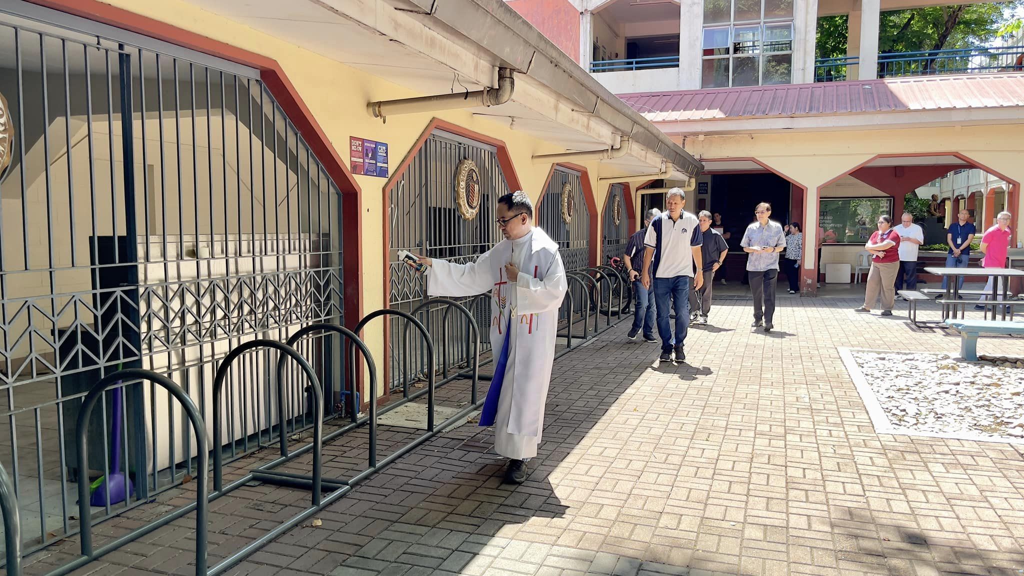 Fr Mamert Mañus SJ blesses the Batch 77’s donated bicycle racks outside the AJHS cafeteria 