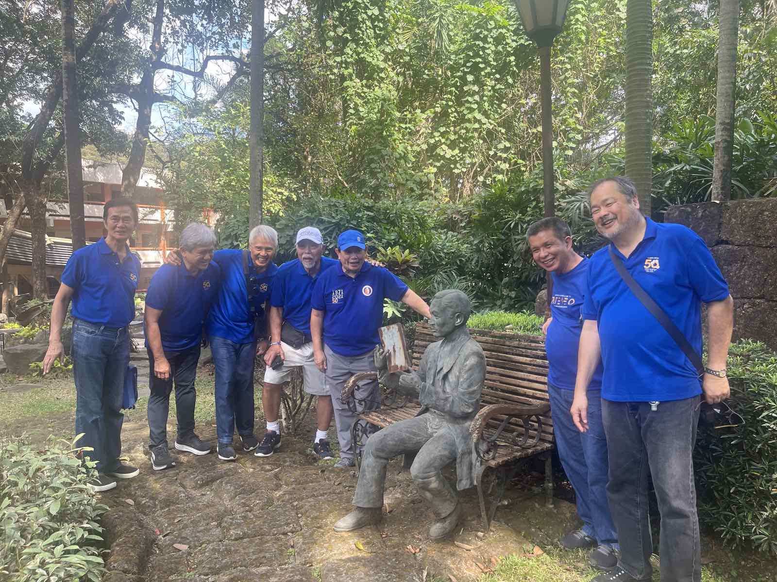 Members of Ateneo College Batch 1975 stand with a statue of a young Jose Rizal in the Zen Garden, Ateneo Grade School