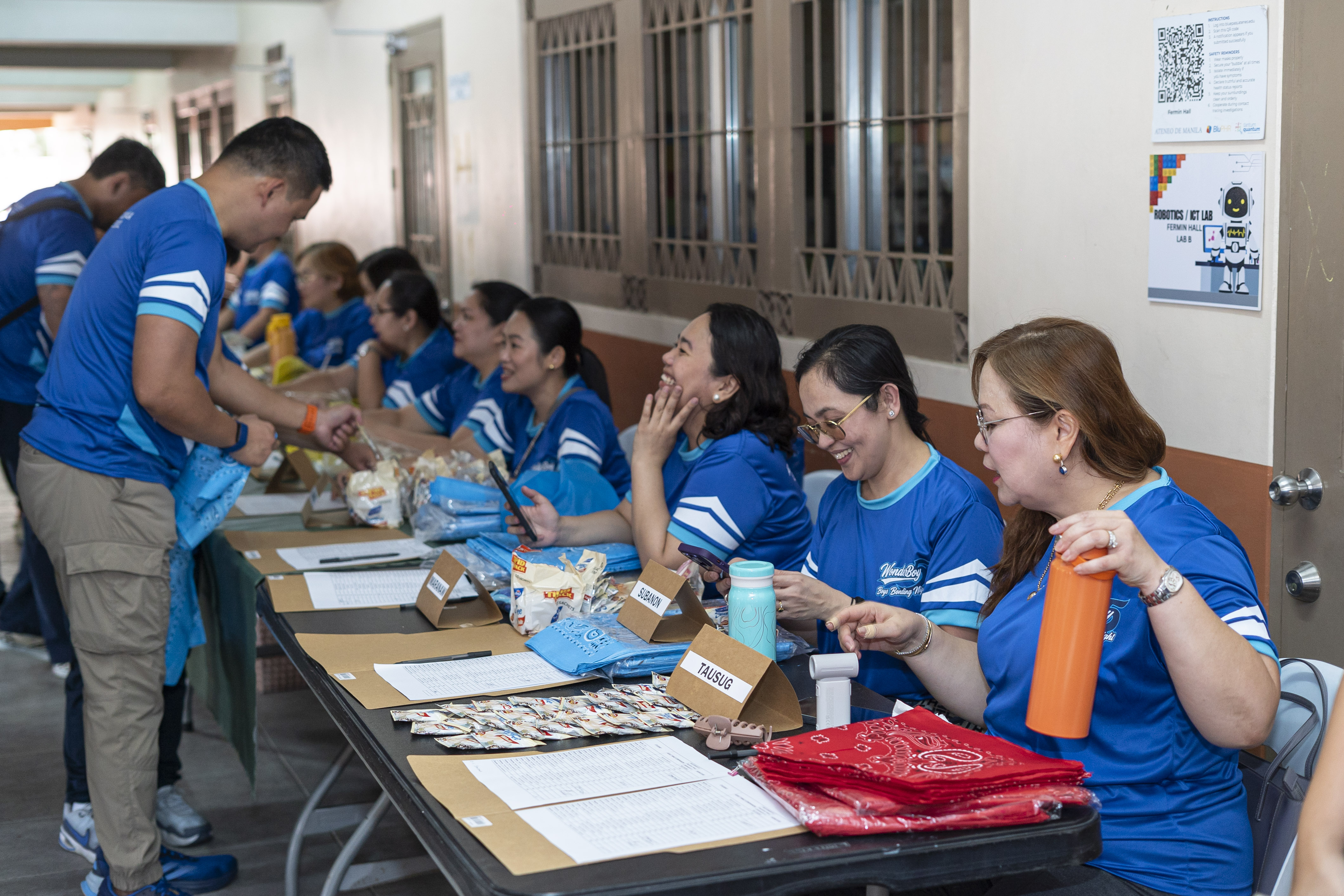Faculty and parent volunteers greet fathers and adult companions at the registration booth