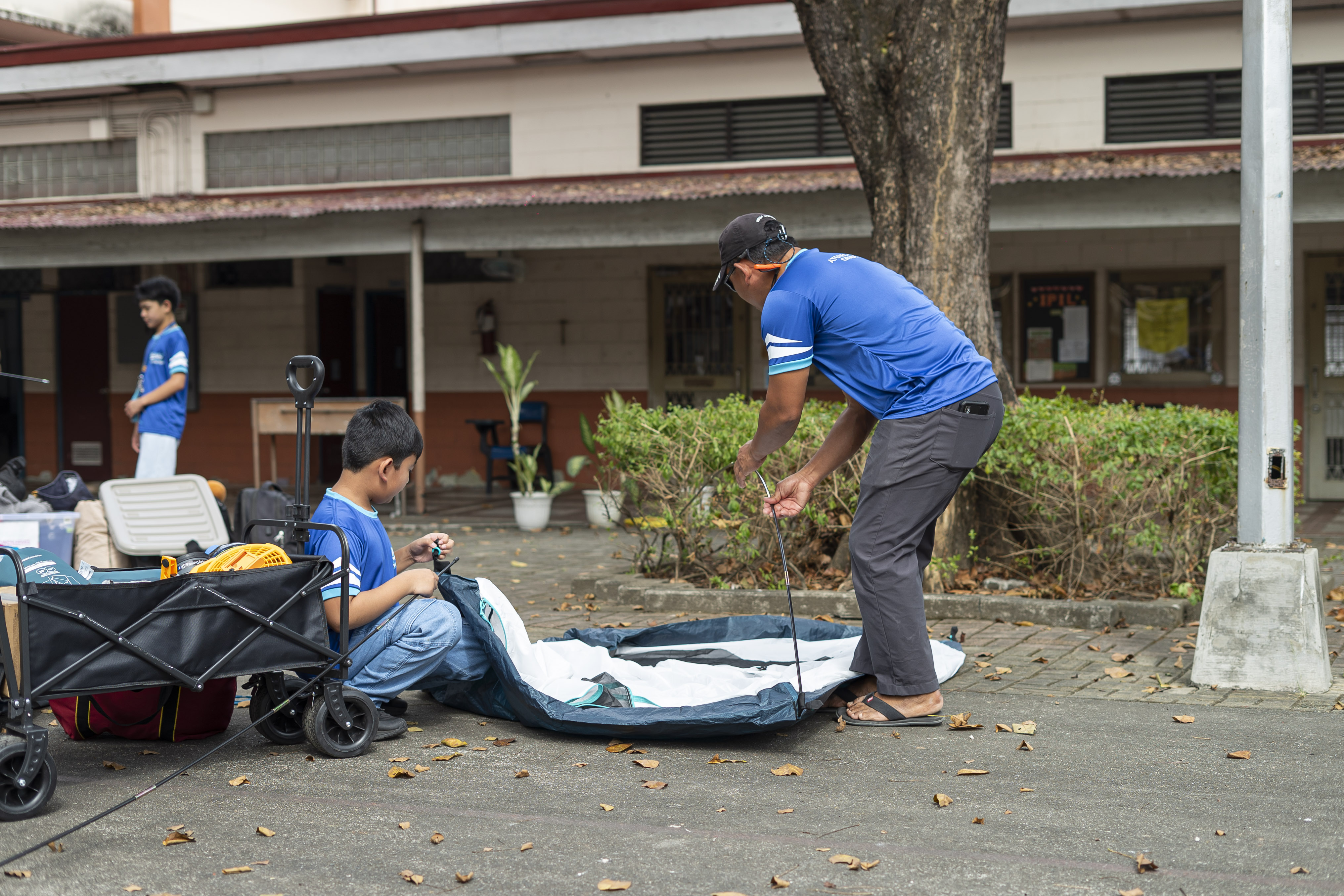 A father and son team up to pitch their tent—bonding in every fold.