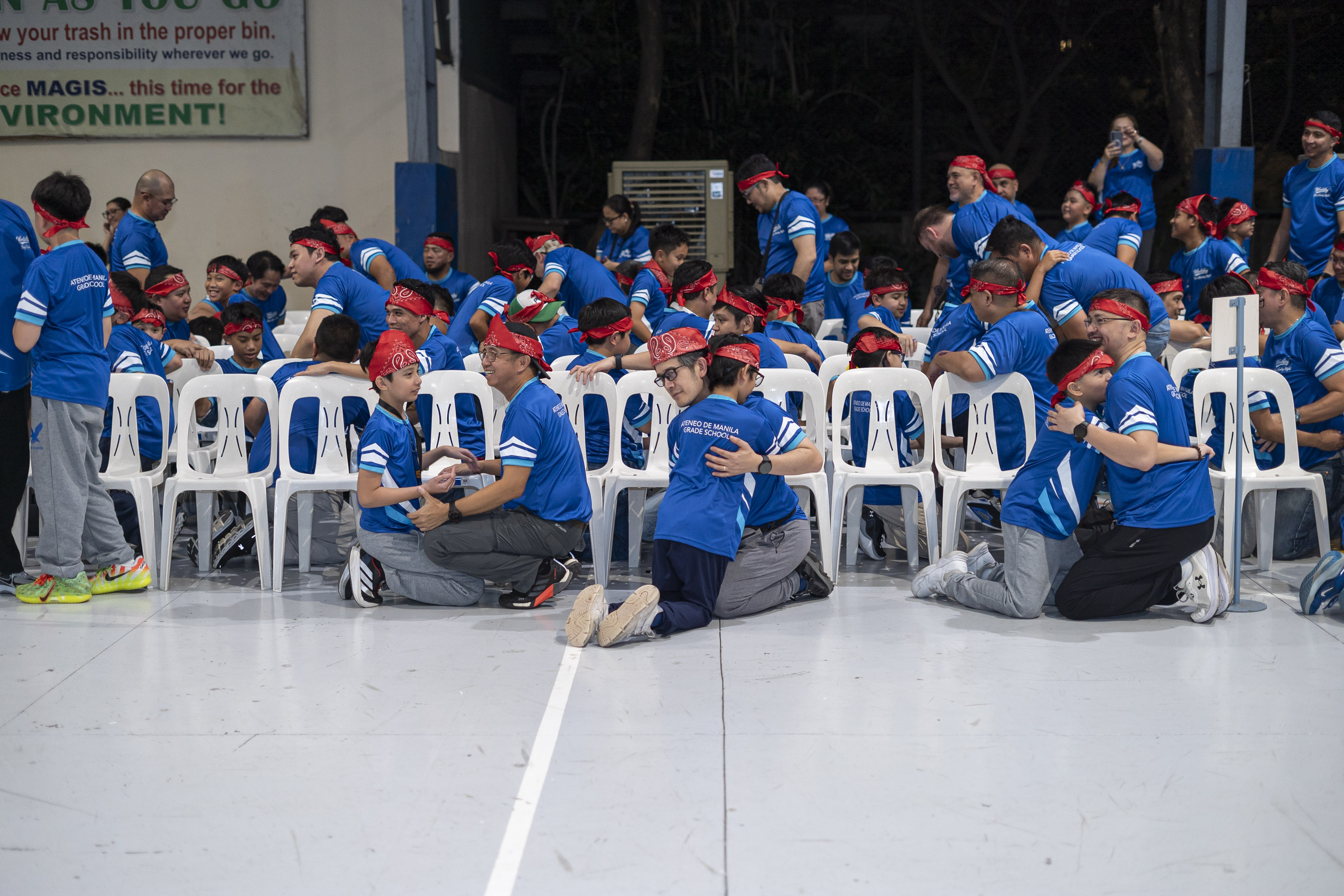 A heartfelt moment as fathers and sons (or adult companions and their teens) share an embrace.