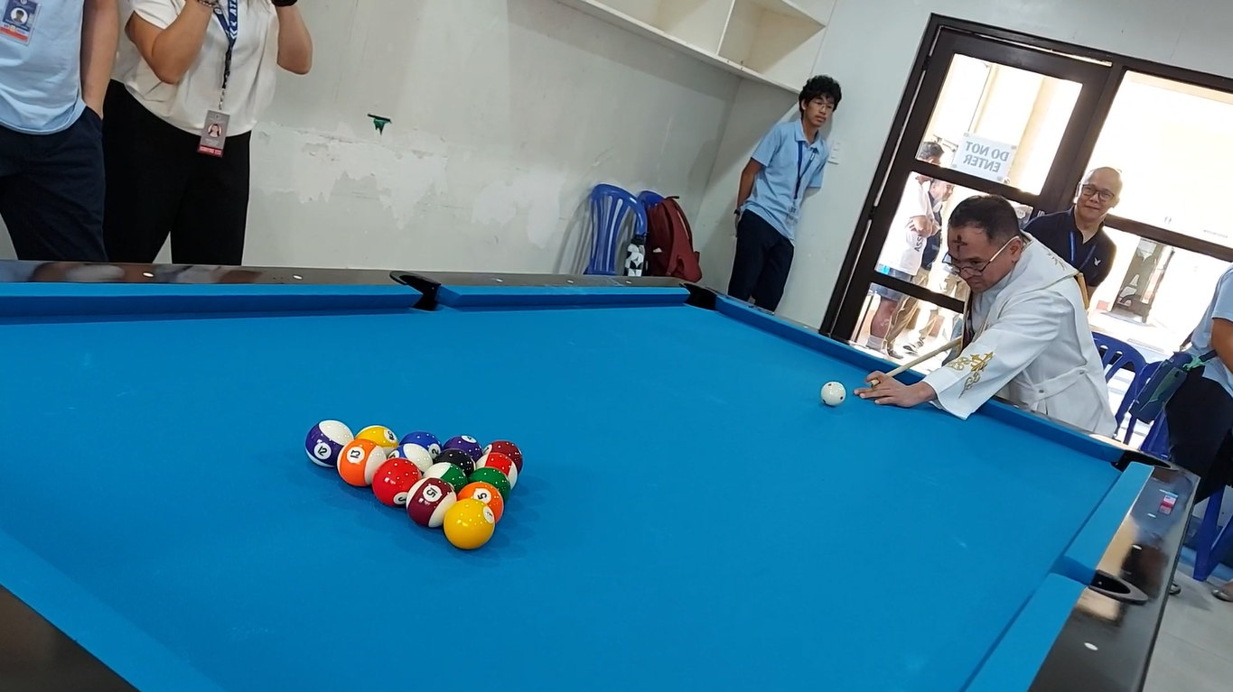 Fr Mamert taking the ceremonial first shot at the billiard table