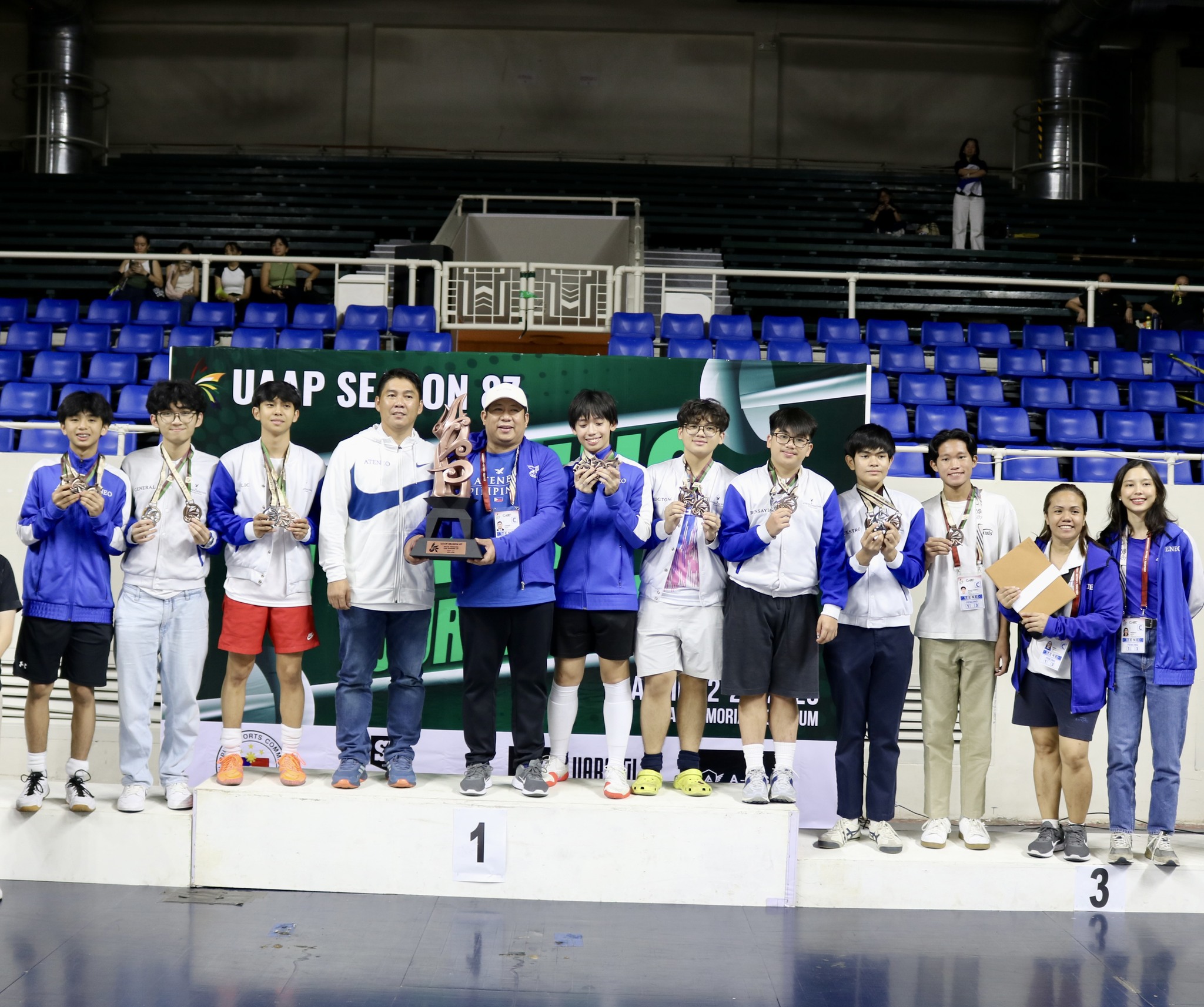 (L-R) Derek Perez, Matthew General, Mairon Moulic, Coach Rupert Endriano, Coach Edward Daliva, Adam Aceron, Albert Pascua, Joaquin Ronsayro, Samuel Gatmaytan, Noah Ibrahim, Coach Veena Nuestro, Coach Bekah Reyno; not in photo: Sean Ang, Zeb Largo   