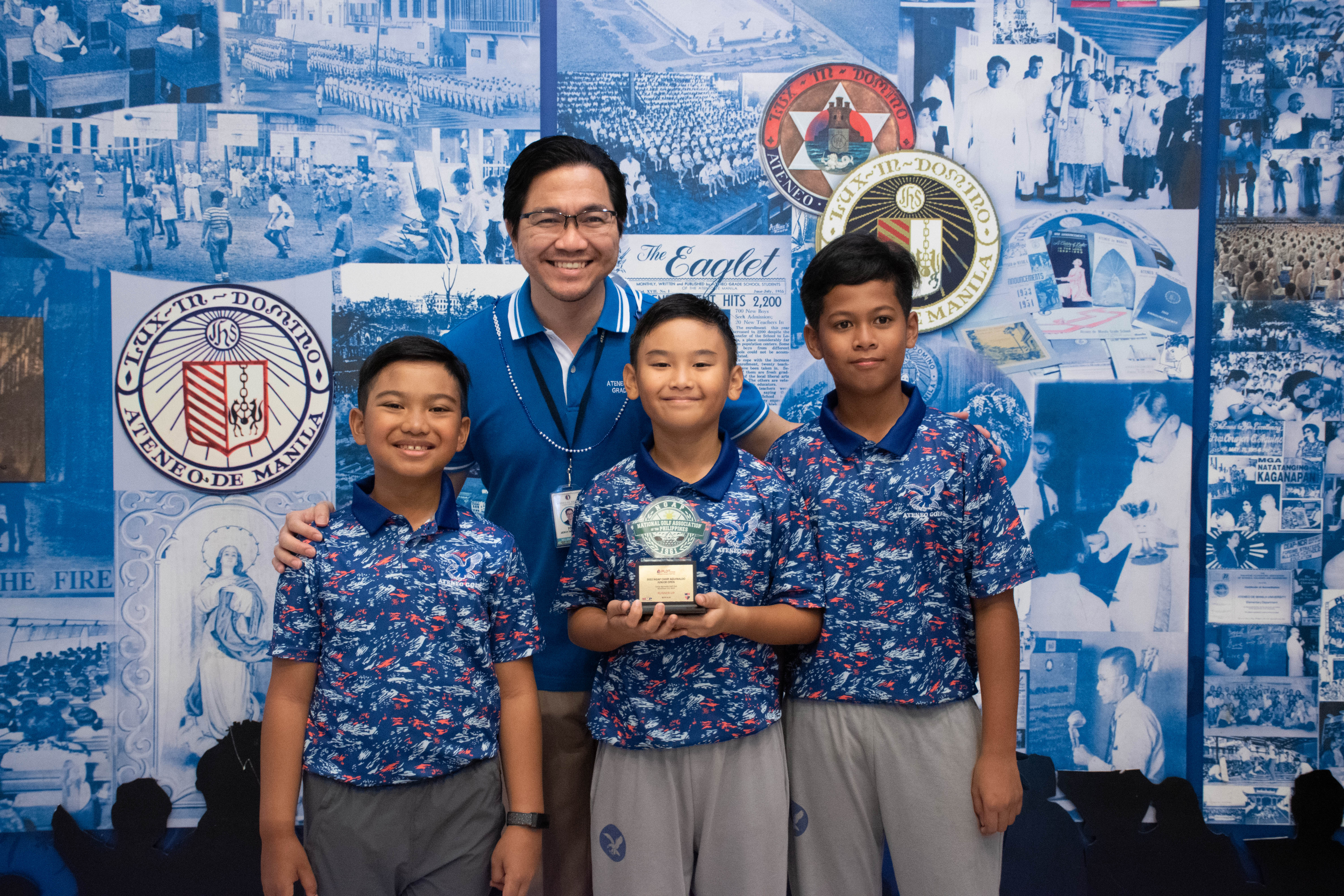 Headmaster Jervy Robles with golf medalists (from left) Race Manhit, Juanton Cruz, and Lujo Gomez 