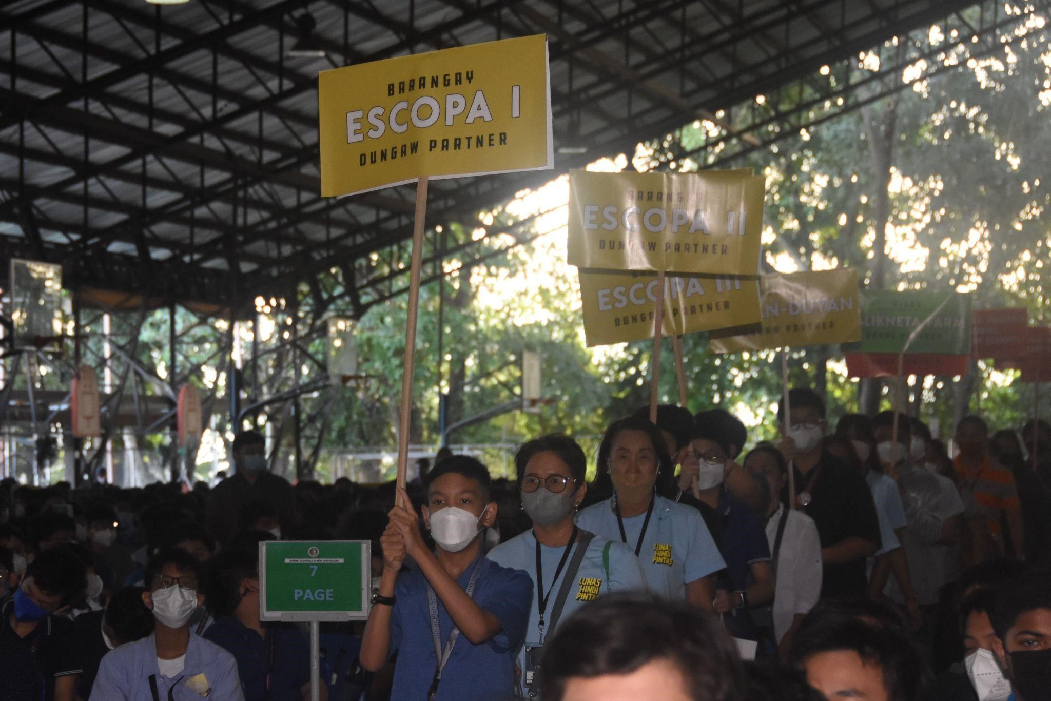 The parade of partners accompanied by student volunteers carrying placards for each area and institution. 