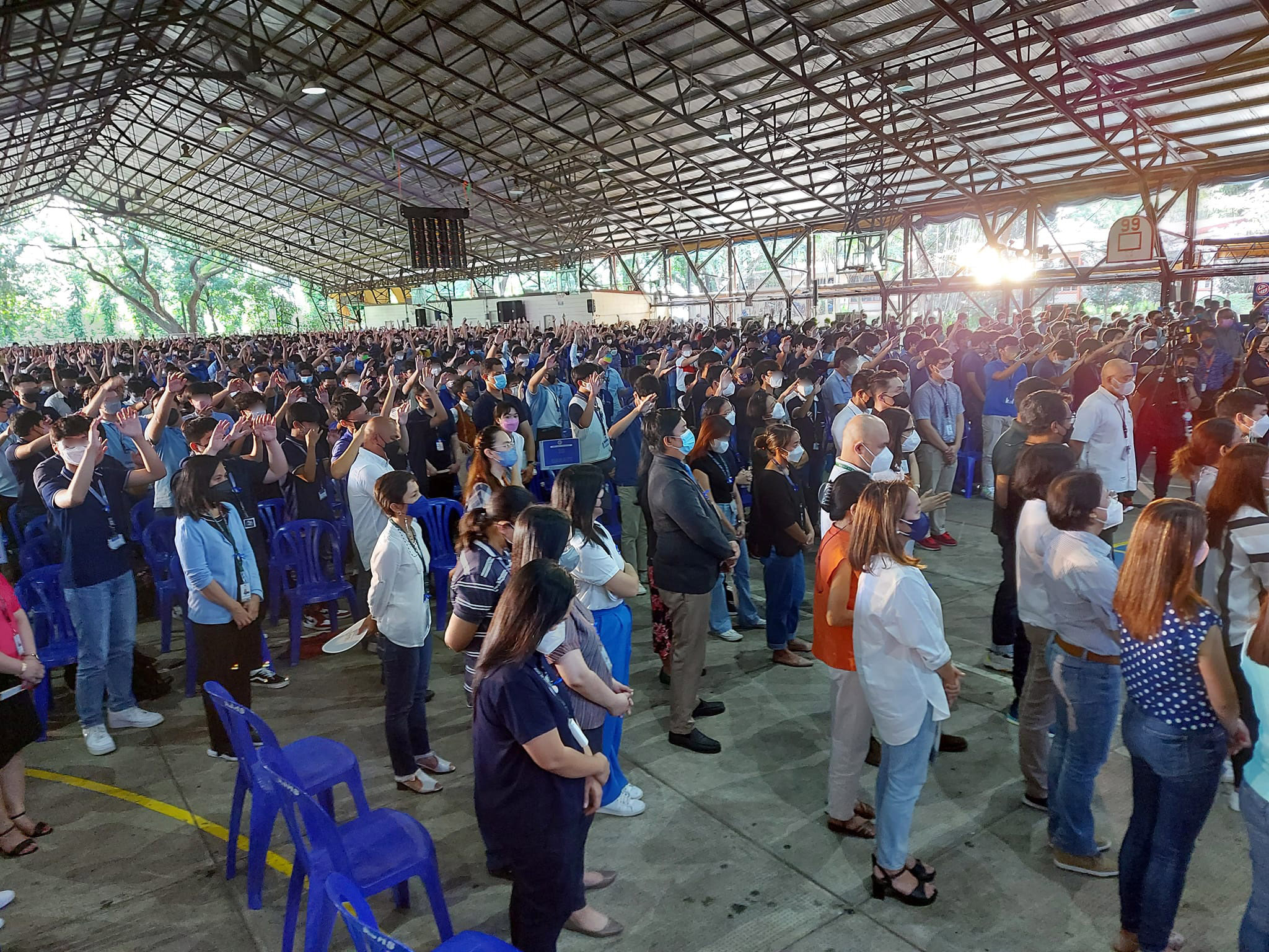 The students symbolically extend their hands over their formators