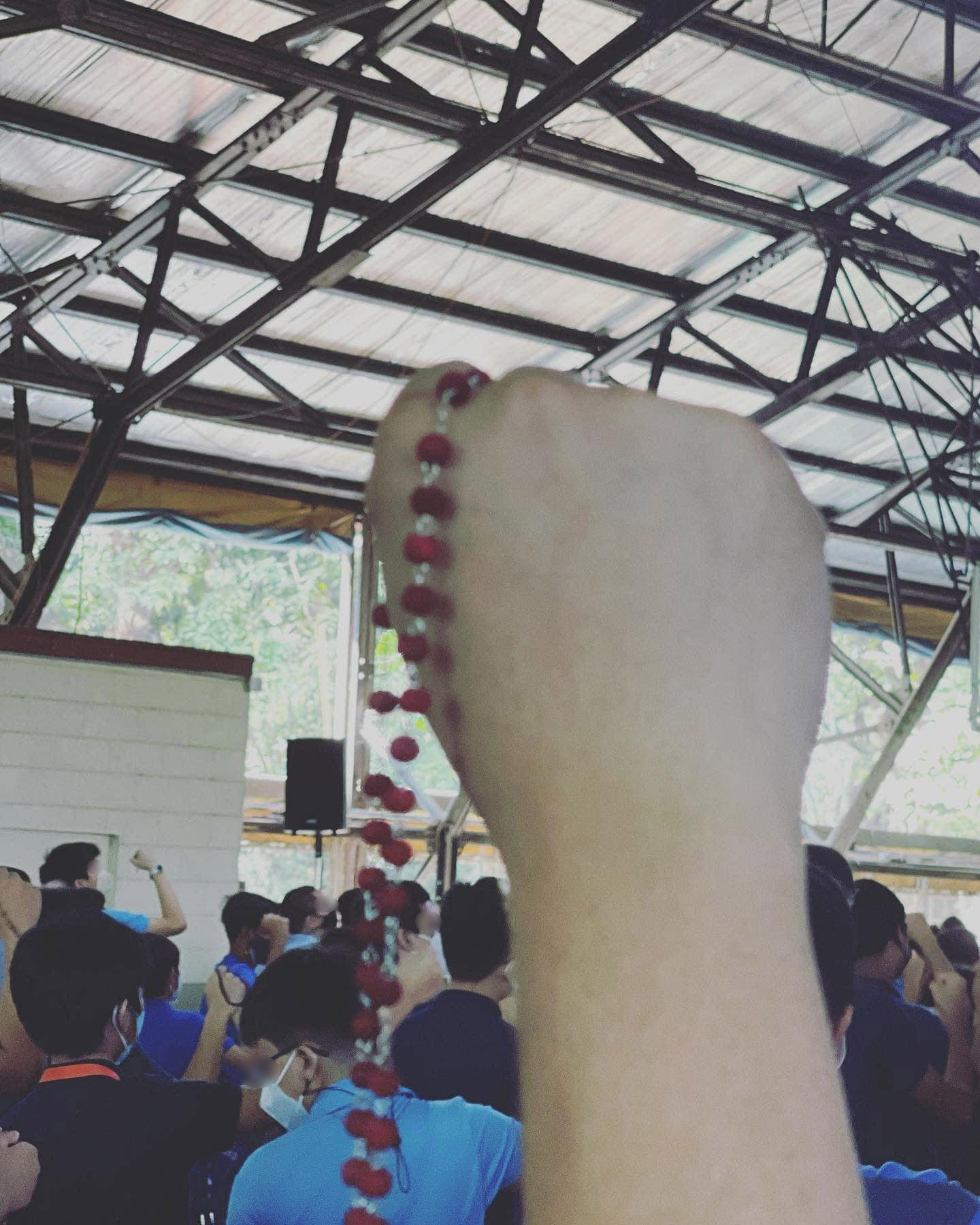 A student holds his rosary aloft during the singing of the Song for Mary
