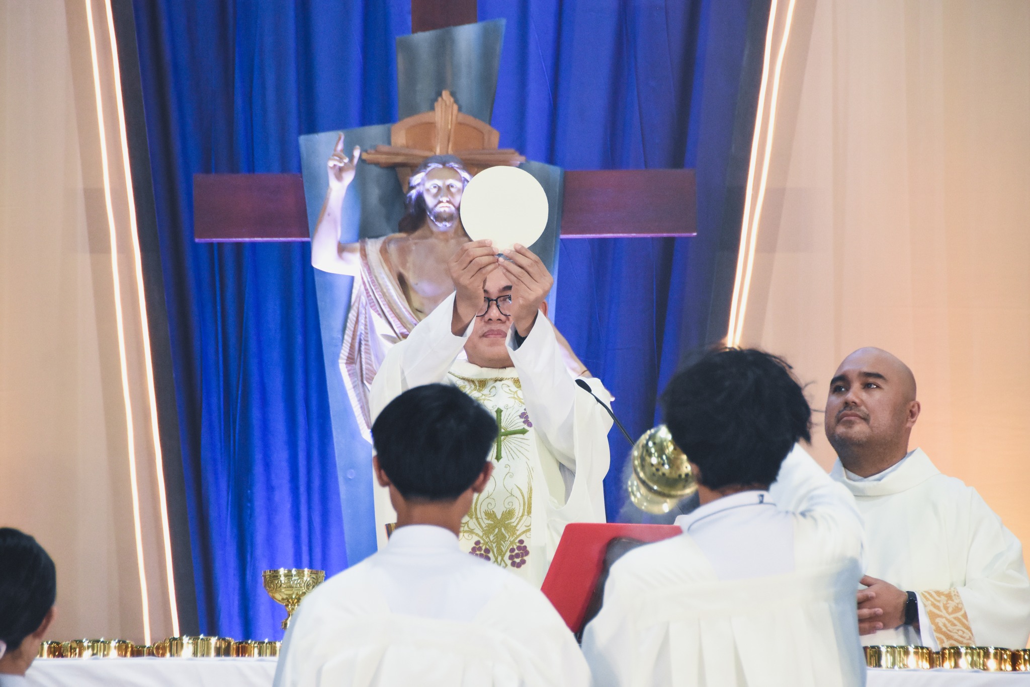 Fr. Xavier L. Olin, SJ, Provincial Superior of the Society of Jesus in the Philippines, lifts the Eucharistic bread during the Easter Mass celebration.