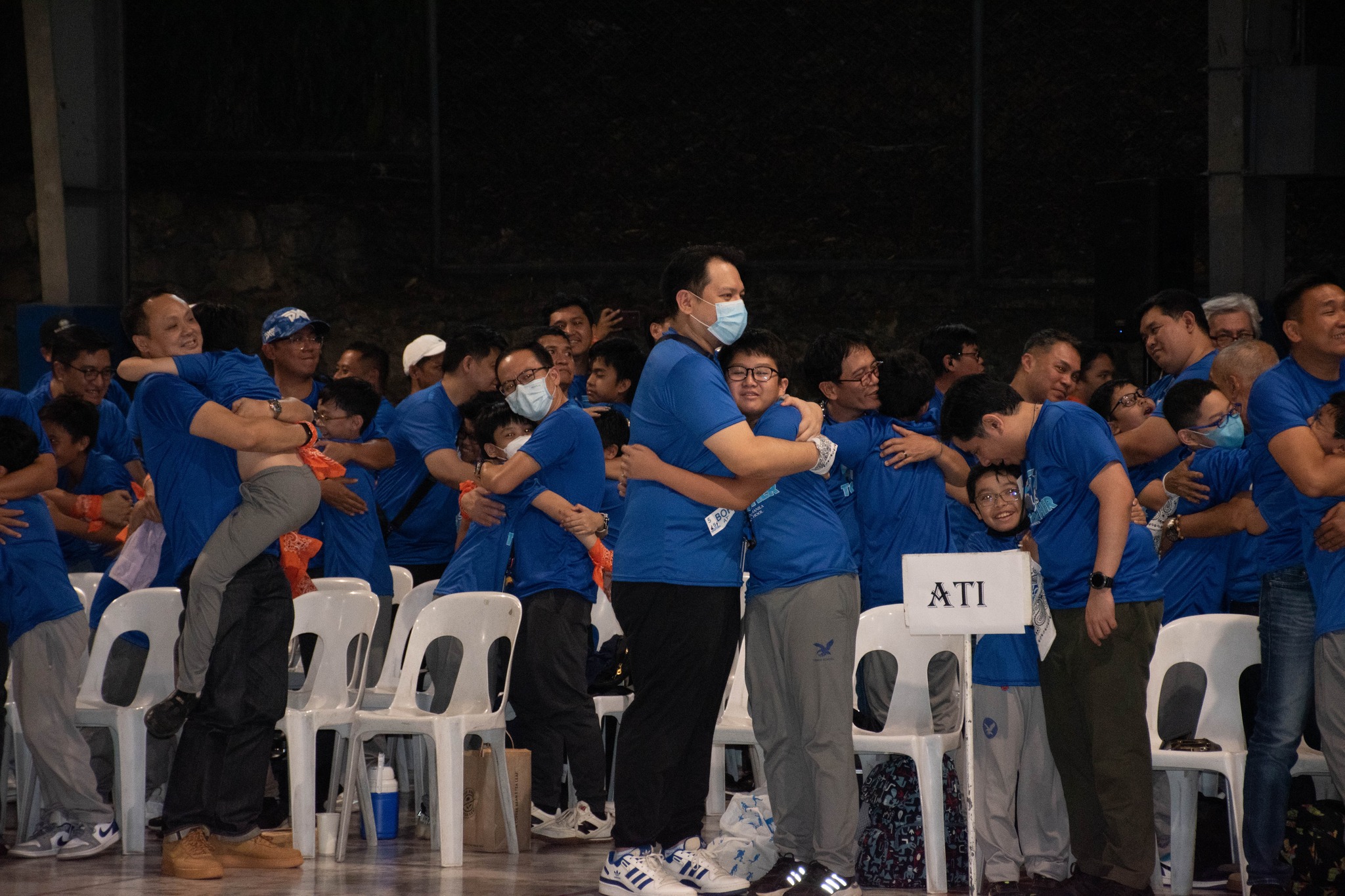 Adult companions and sons sharing an 'ionic bond hug' 