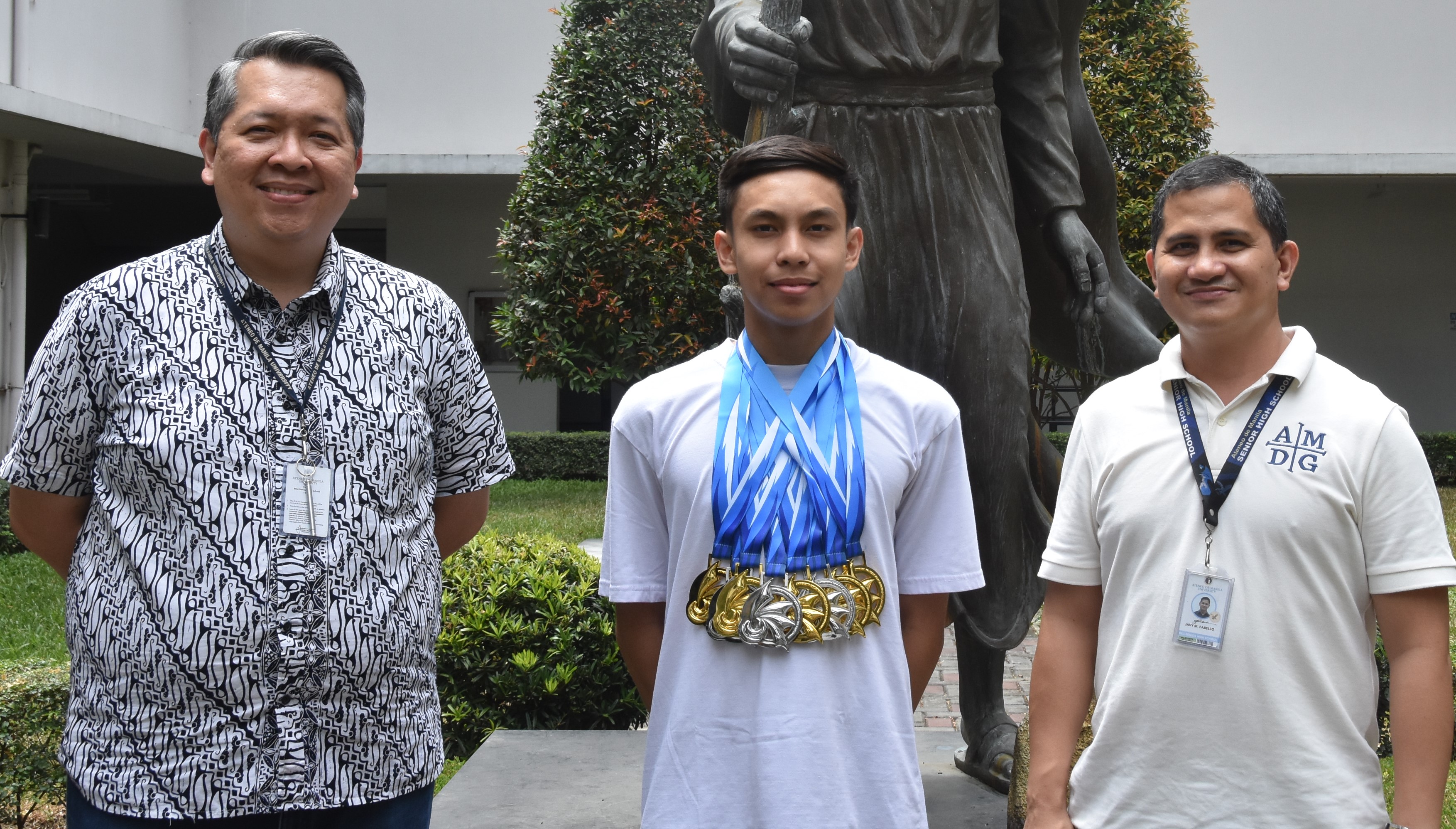 Flanked by Noel Miranda (left) and Javy Fabello (right), Ivo Enot is photographed wearing the seven medals (5 golds, 2 silvers) he collected at the UAAP Season 85 Swimming Championships. 