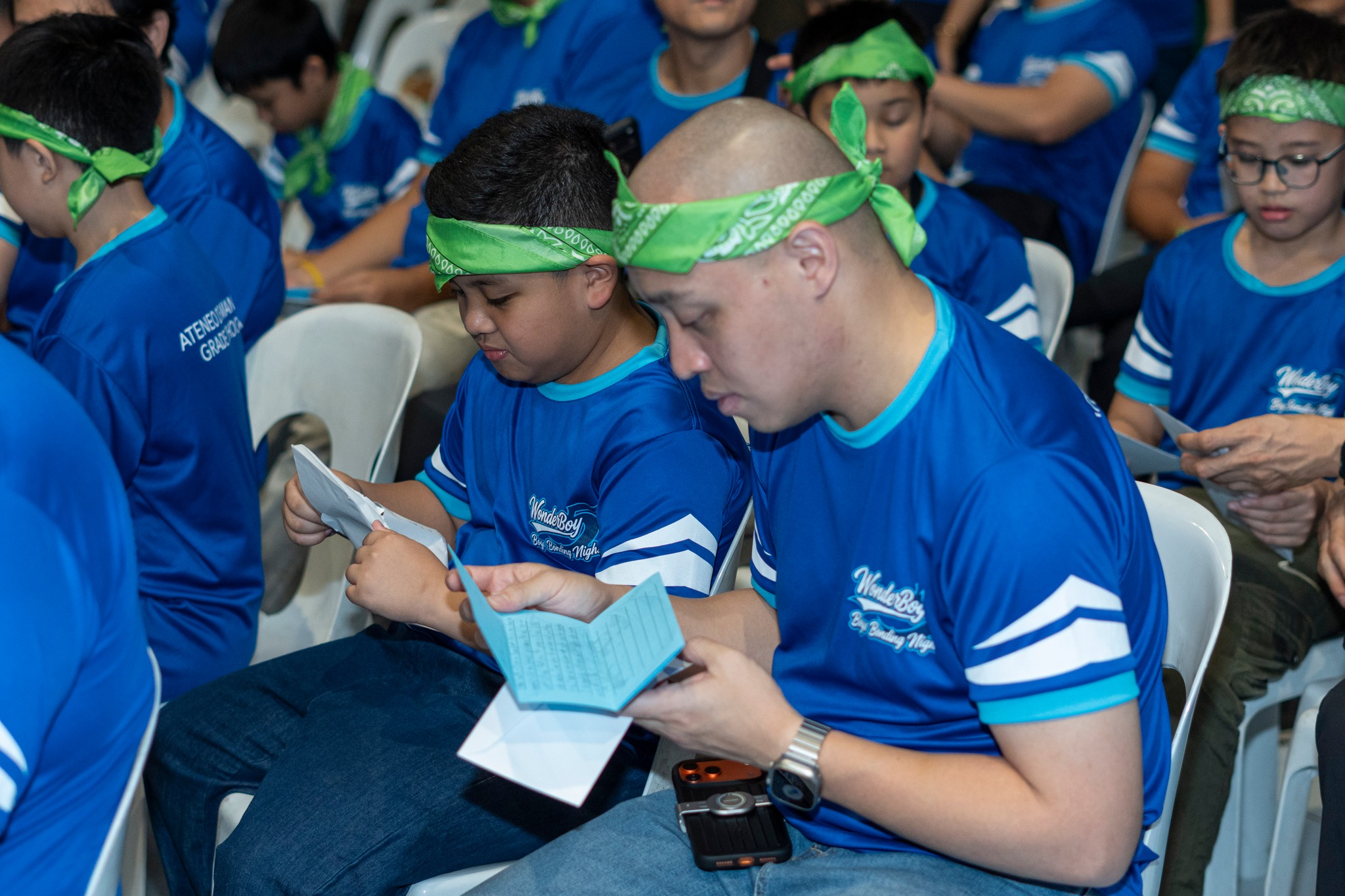 Fathers or guardians and their sons or wards read the letters together.