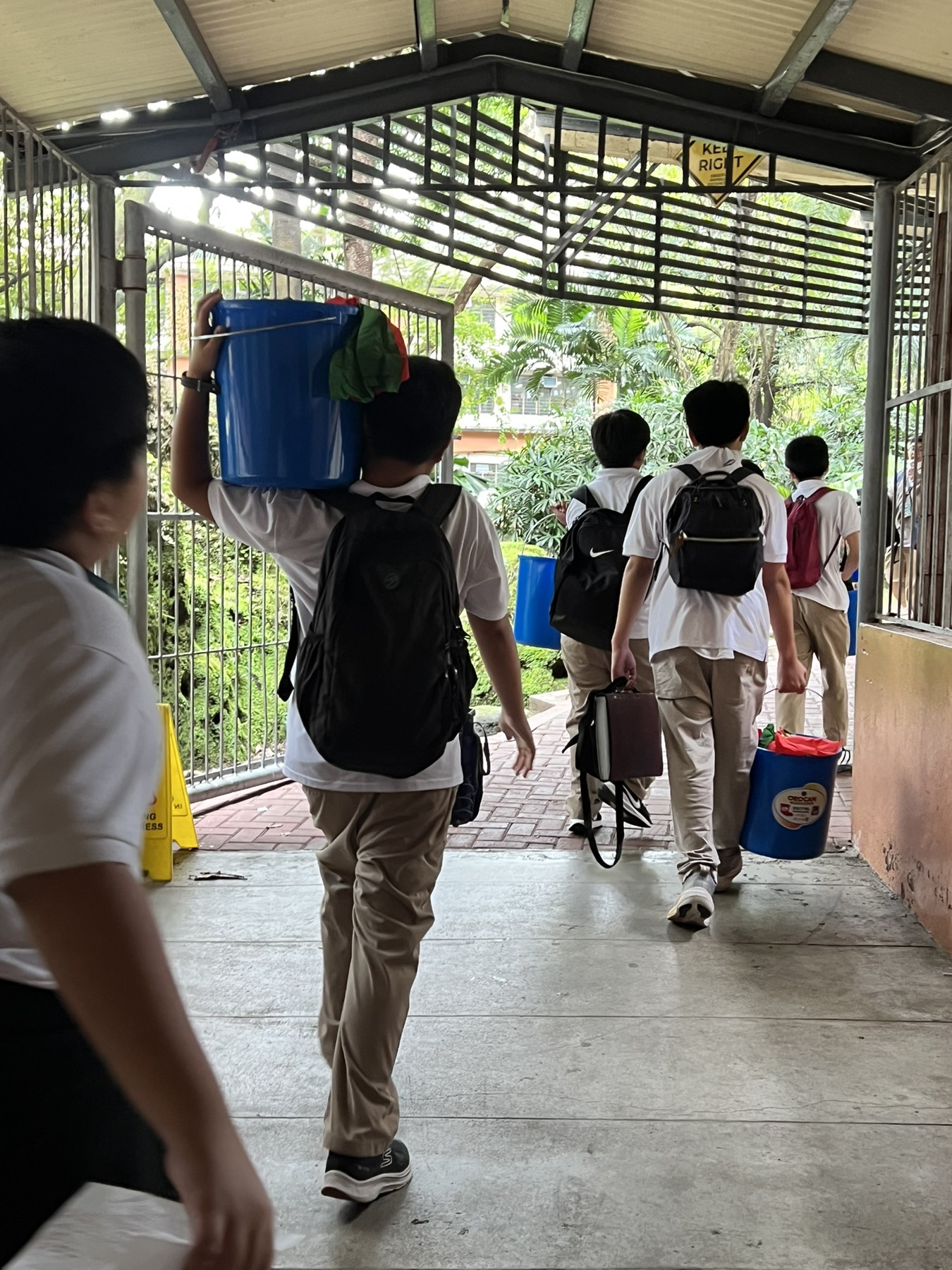Grade 6 boys carrying pails containing groceries and Christmas greeting cards