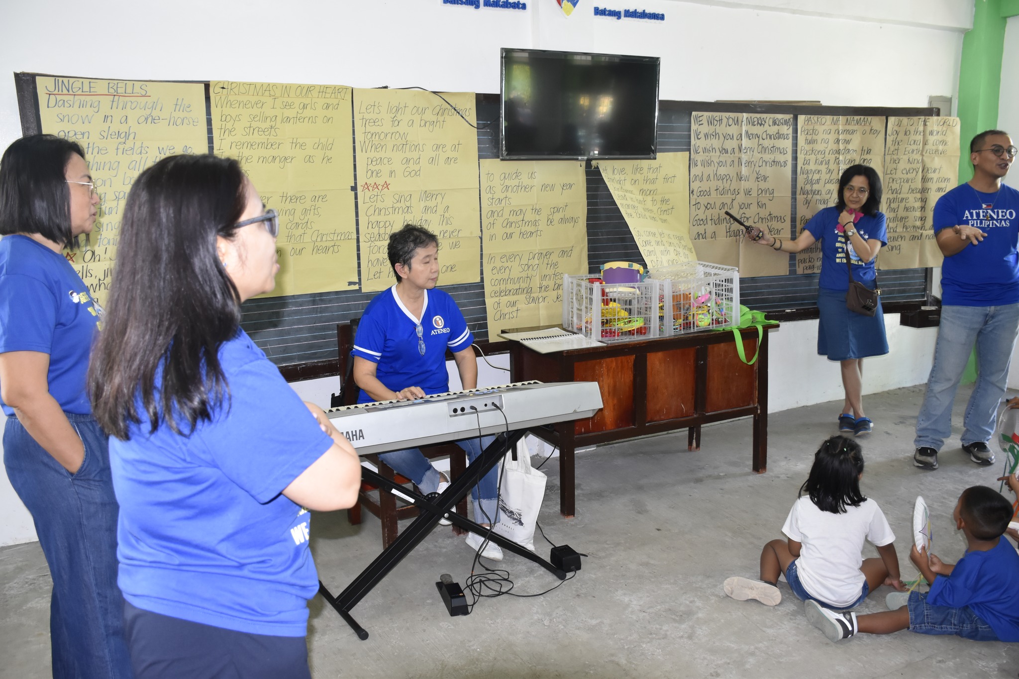 AGS teacher volunteers teaching Christmas songs to the GK Kalayaan childre