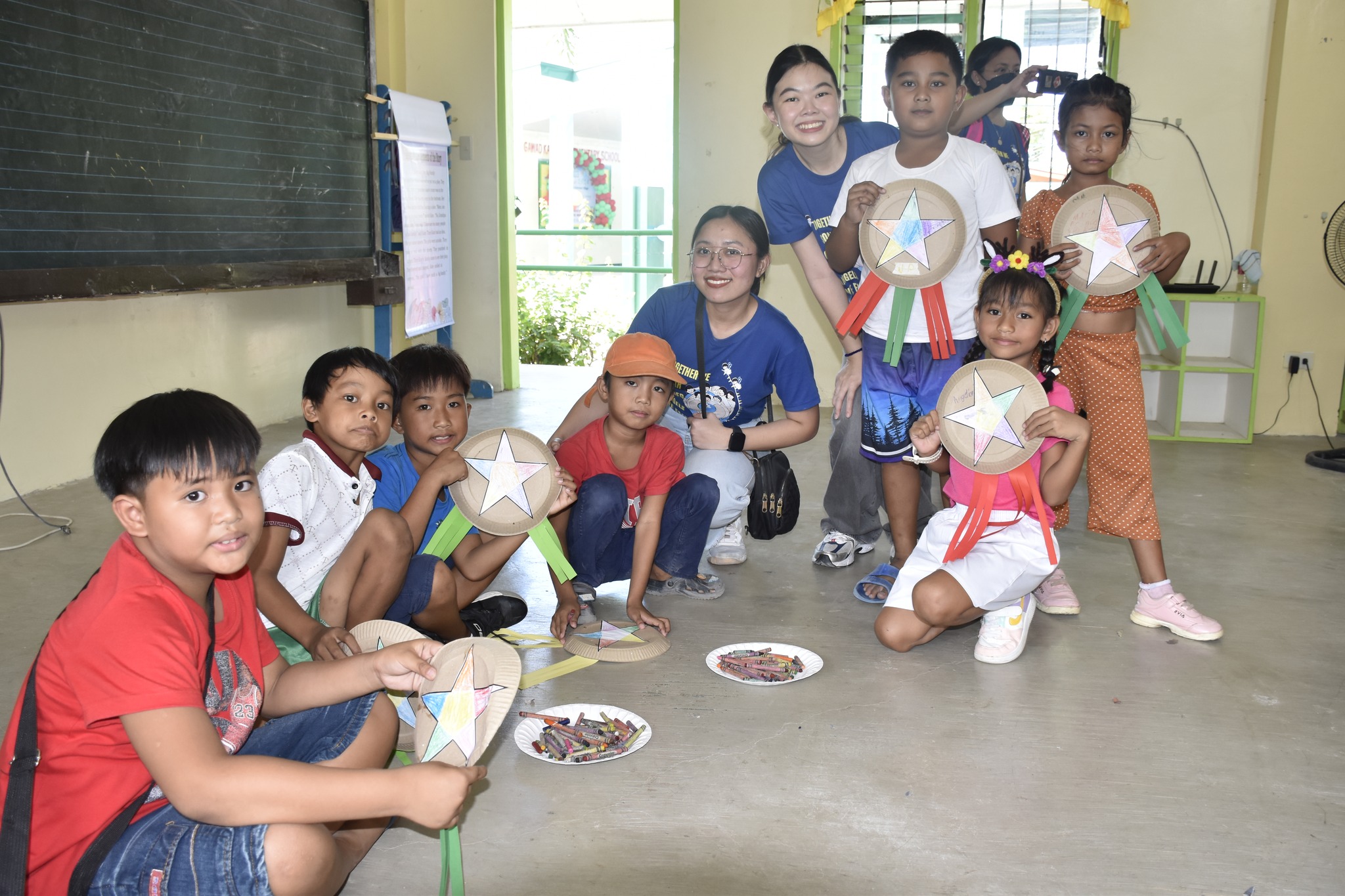 GK Kalayaan children with AGS teacher volunteers showing their parols 