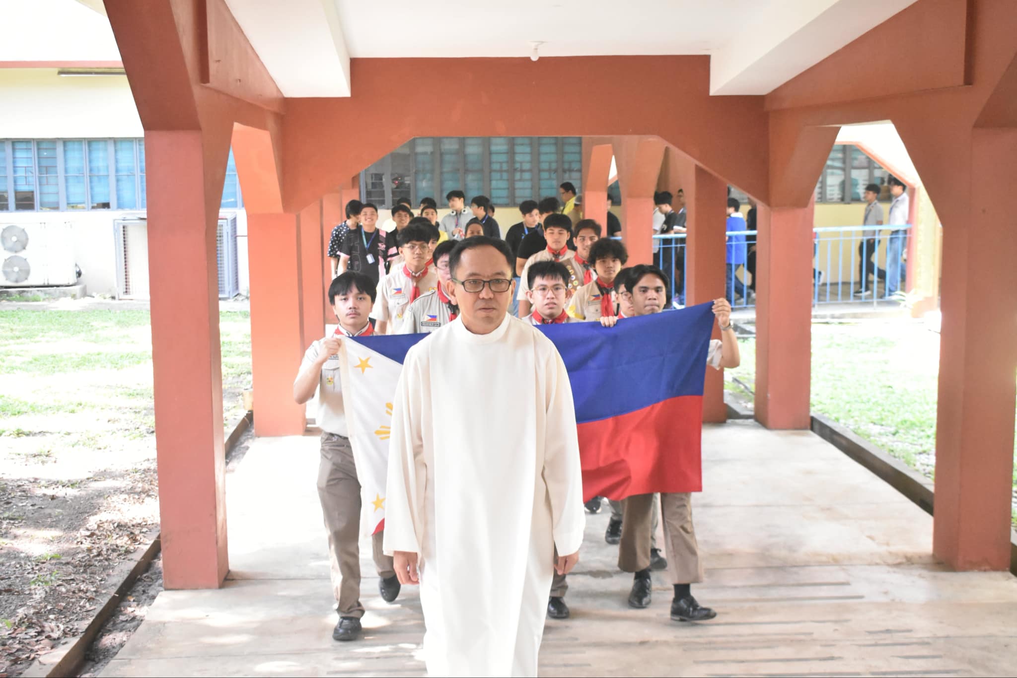 Shepherded by AJHS Chaplain Fr. Mamert Mañus SJ, a troop of AJHS Scouts bears the Philippine flag