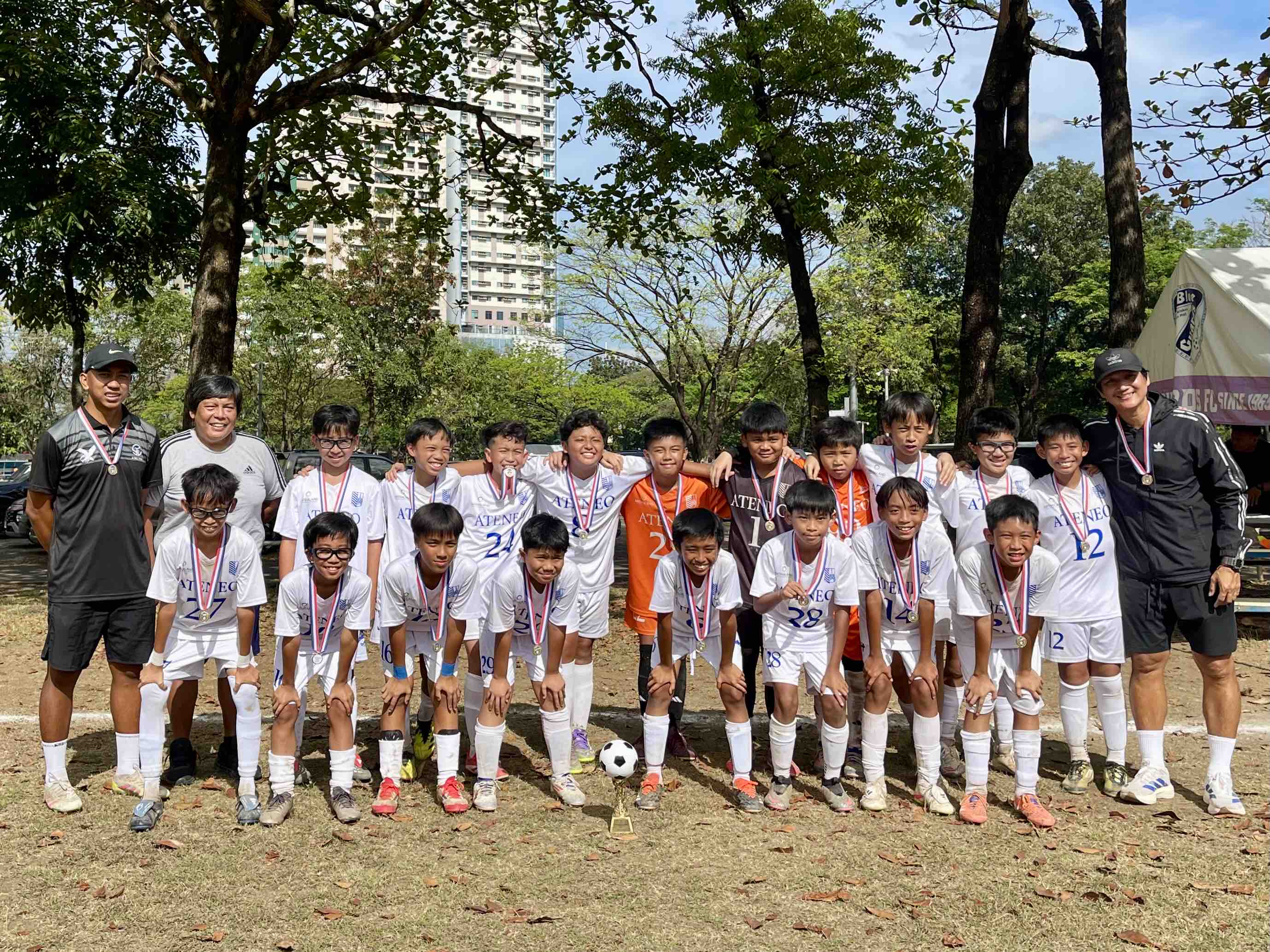 Front row (L-R): Max Unson, Gabby Villanueva, Javi Sumpaico, Evan Tupaz, Luis Vergara, Migo Gerial, Alonso Azores, Sochi Osite; back row (L-R): Coach Rafael Cruz, Coach Bob Manlulo, Miro de Guzman, Maru Esgrina, Aaron de Villa, Yñakhi Lao, Andrei Castañeda, Marcus Tale, Hyde David, Zico Mendoza, Lucas Chuidian, Anton Landicho, Coach JR Judal 