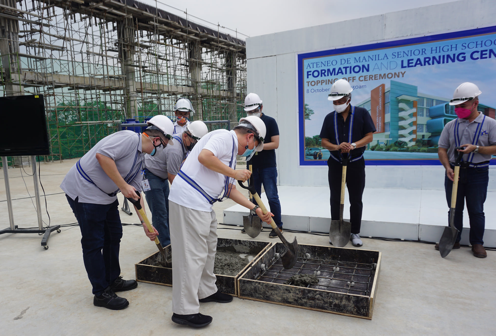 ASHS Principal Noel P Miranda (front left) and University President Fr Roberto C Yap SJ (front right) begin the ceremonial topping-off 