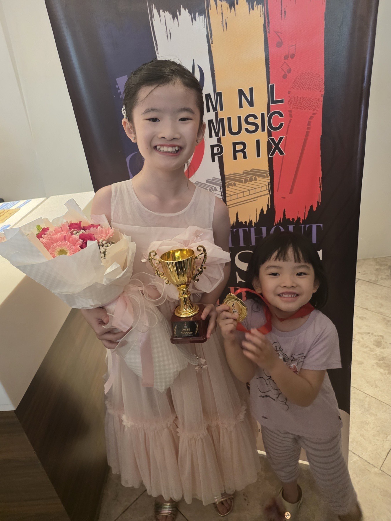 A triumphant Zia Uy at the MNL Music Prix with her baby sister 