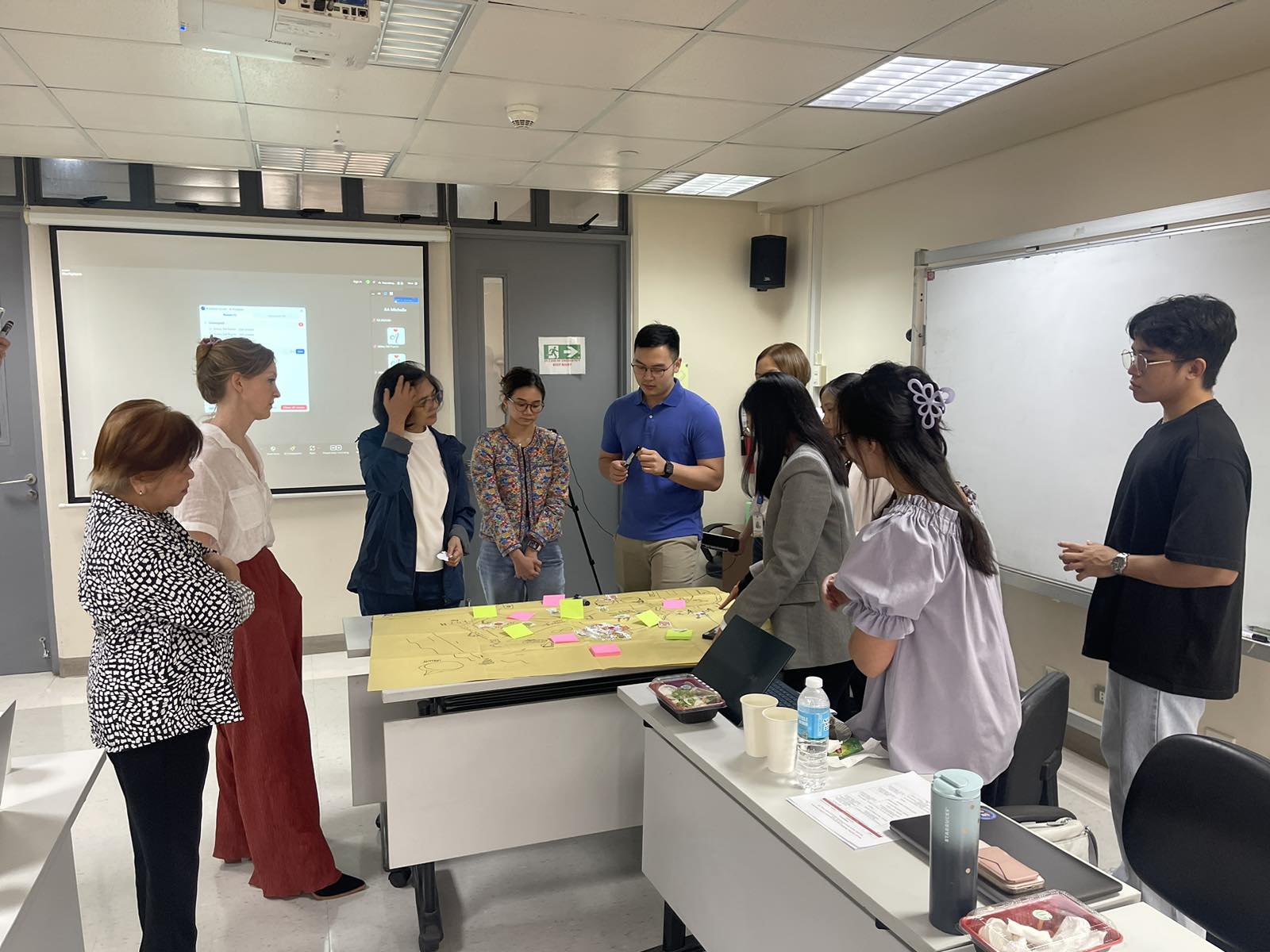 A photo of participants discussing in front of a flipchart