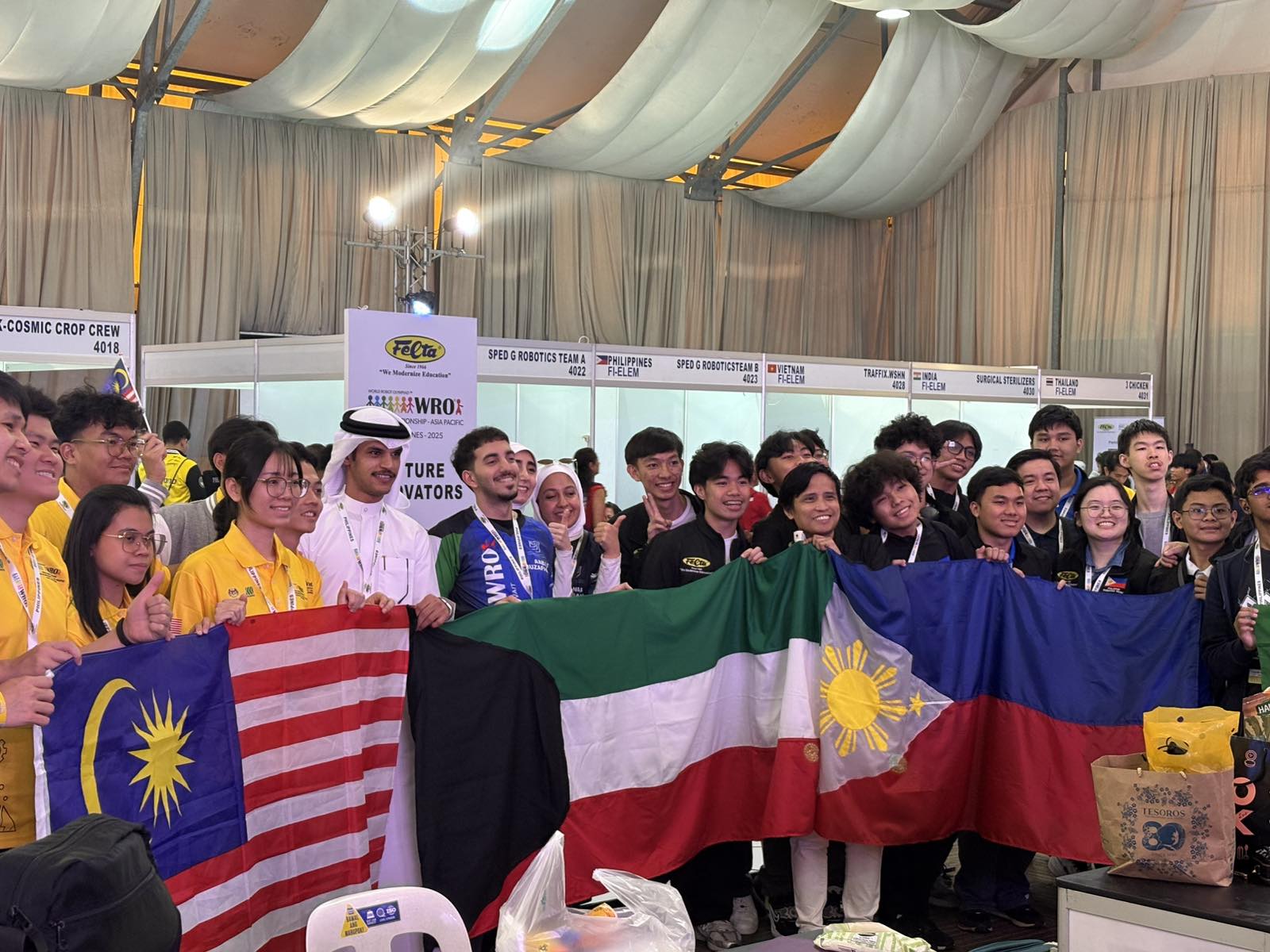 The WRO Future Engineers teams from Malaysia, Kuwait, the Philippines, Hong Kong, and Bangladesh pose for group photos on the playing mat after the competition.