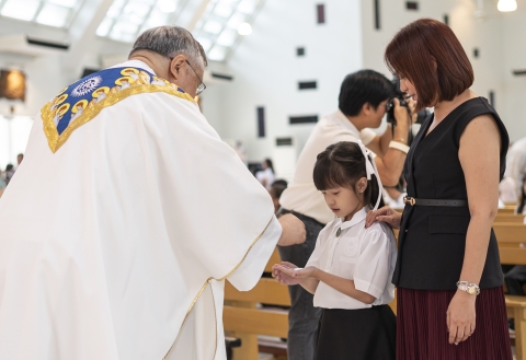 A grade 2 girl receiving her First Holy Communion    