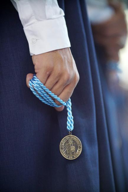 LS graduate clutching an Ateneo graduation medal