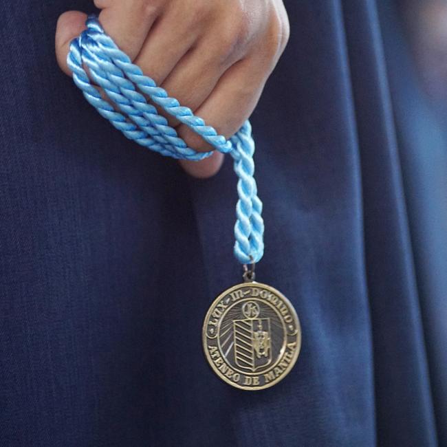 Candidate for graduation clutching the Ateneo graduation medal