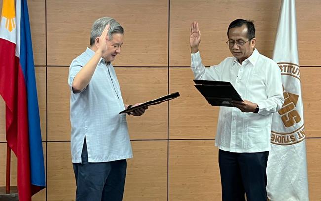 Fr Roberto Yap SJ being sworn in as the newest member of the PIDS Board of Trustees by NEDA Sec Arsenio Balisacan, PIDS BOT chairperson