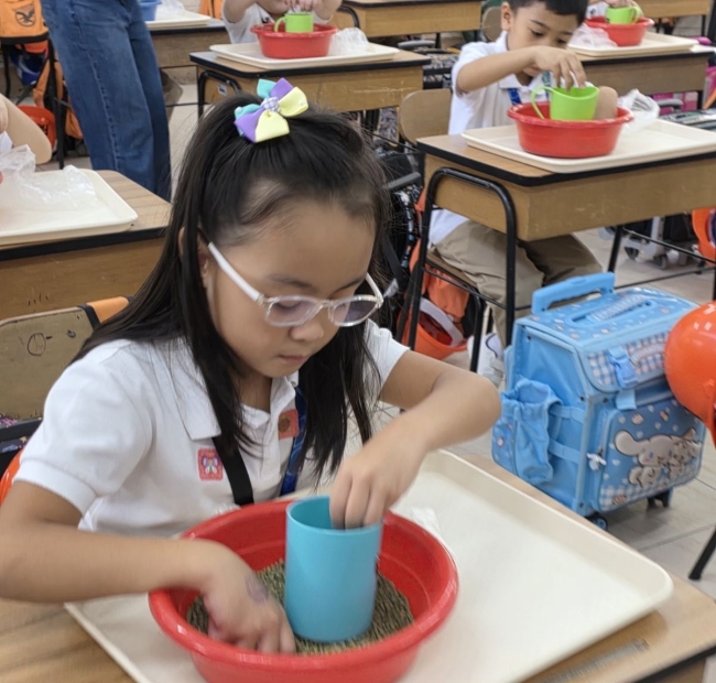 Grade 1 students repacking monggo beans for partner communities 